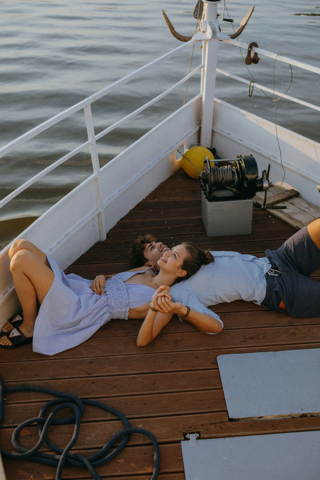 Two people relaxing on the wooden deck of a boat